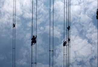 Trabalhadores atuam em cabos de linha de transmissão de energia em Dongguan, na China - Reuters/Stringer