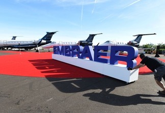 Funcionários ajeitam letreiro da Embraer durante exposição em Las Vegas - REUTERS/David Becker